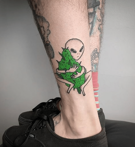 tatuagem de um alien abraçando um camarão de maconha