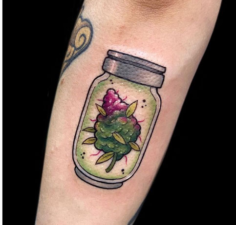 tatuagem de flor de maconha dentro de um pote