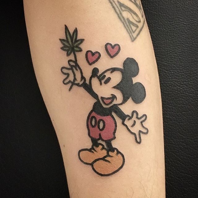 tatuagem do mickey segurando uma folha de maconha