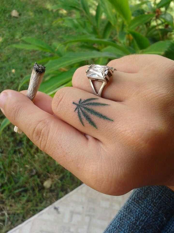 tatuagem de folha de maconha pequena no dedo